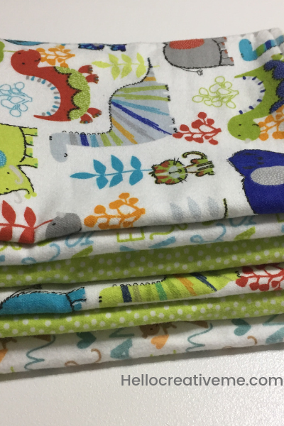 stack of white and green DIY baby burp cloths