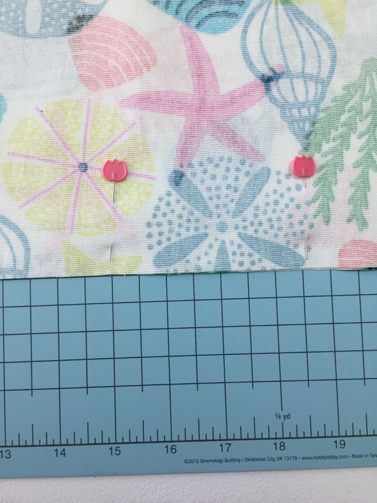two pieces of fabric pinned right sides together on cutting mat