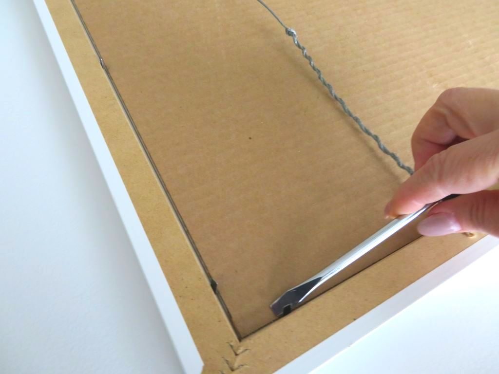 prying off backing of artwork using screwdriver