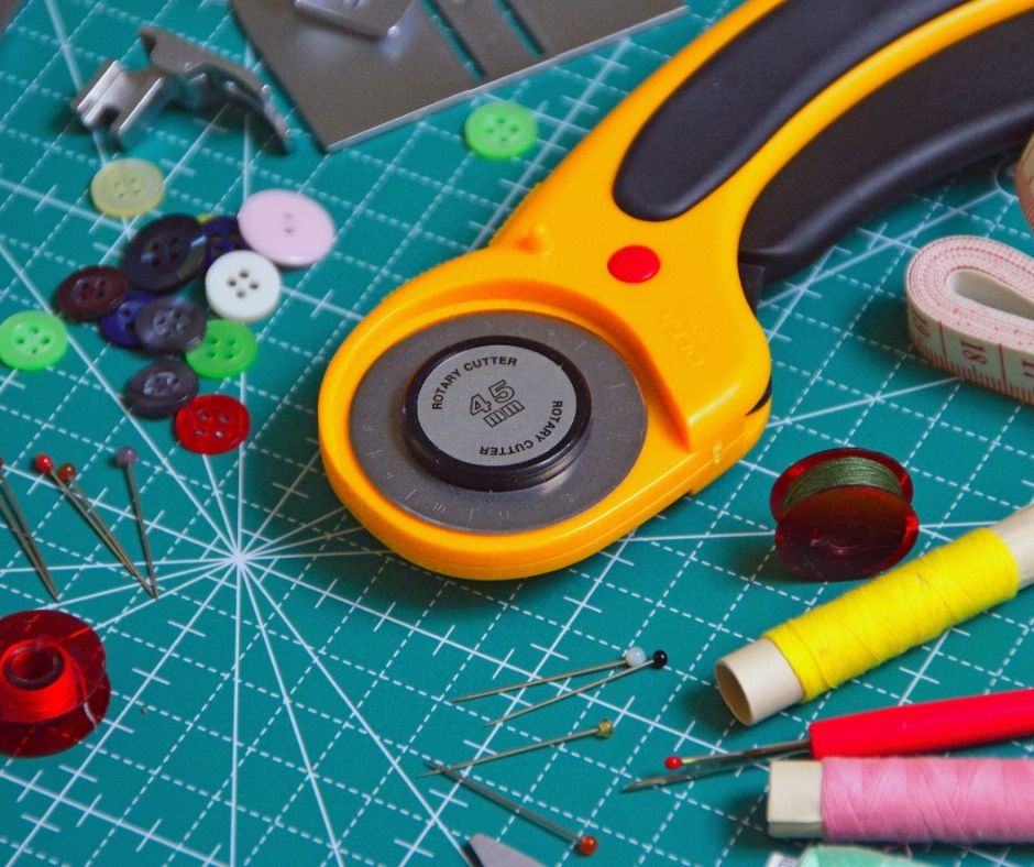 buttons, thread, and pins on sewing mat