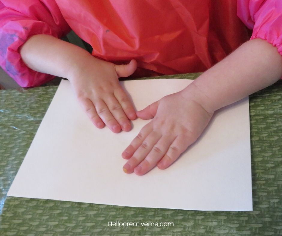 child with hands on white paper