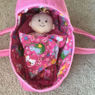 baby doll in pink handmade fabric doll basket.