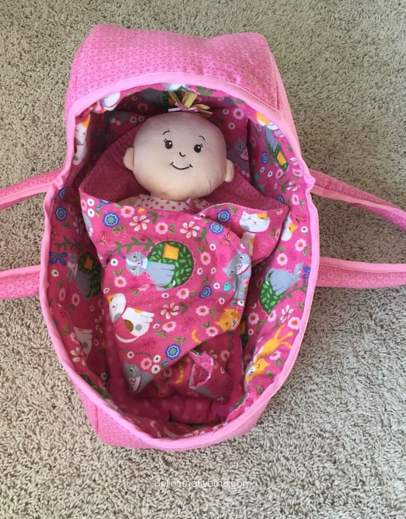 baby doll in pink handmade fabric doll basket.