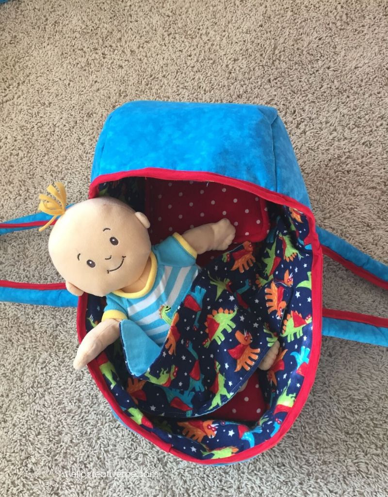 baby doll in blue doll basket