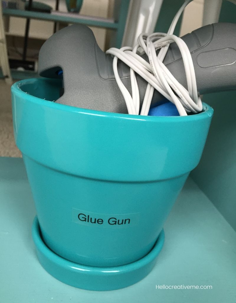 blue flower pot with glue gun in it