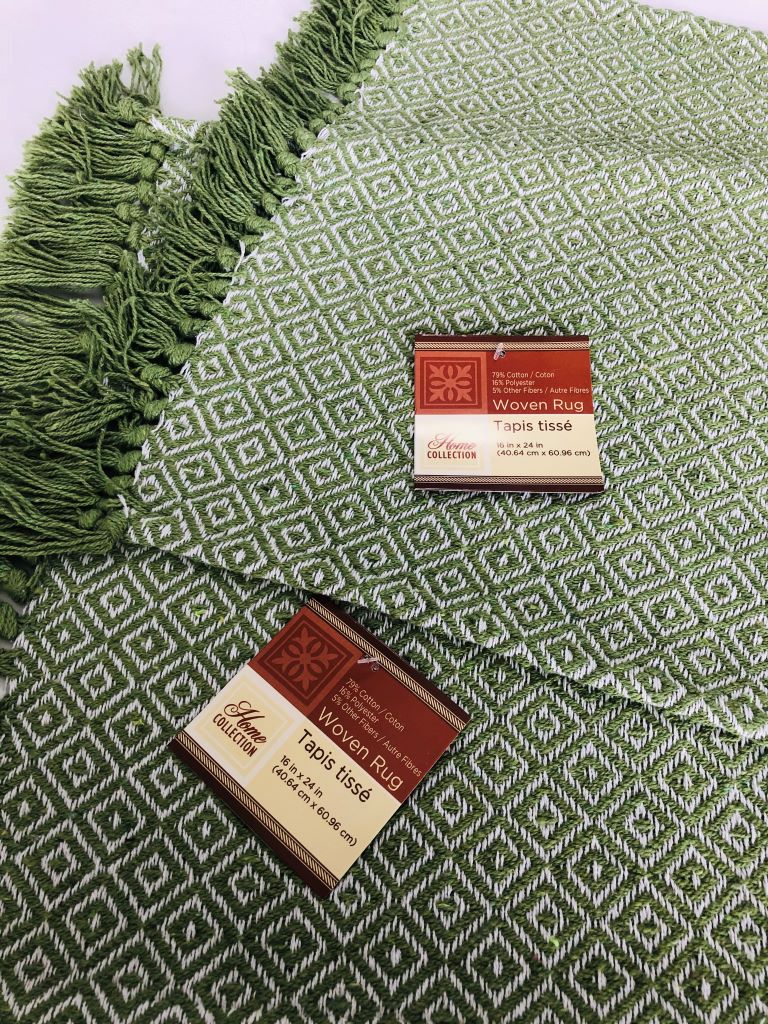 close up view of two small green throw rugs with fringe