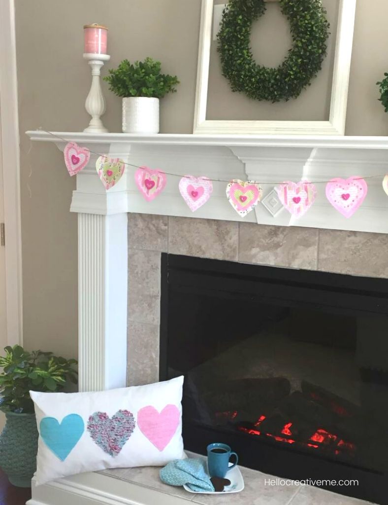 Simple valentine decor with heart pillow in front of fireplace with heart banner