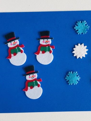 snowmen and snowflake stickers on blue background
