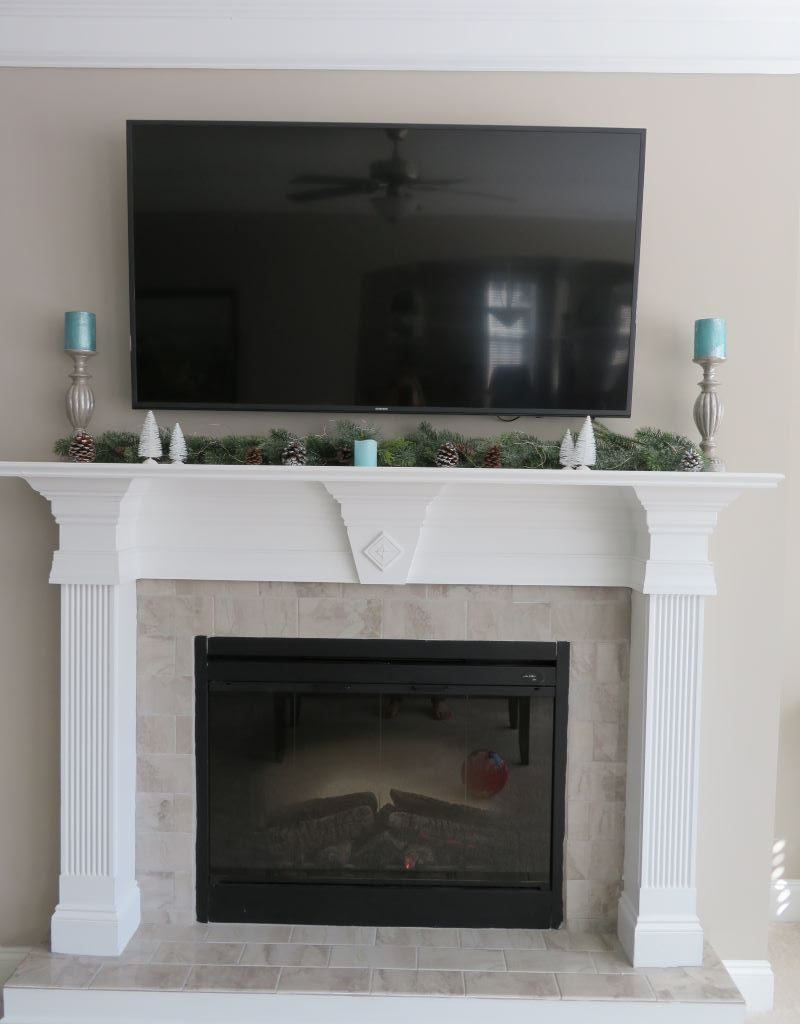Living room fireplace mantel decorated for winter.