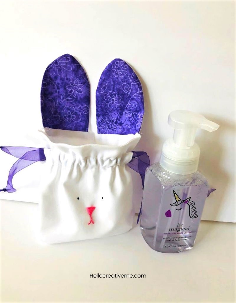 White DIY bunny bag with purple ears next to hand soap