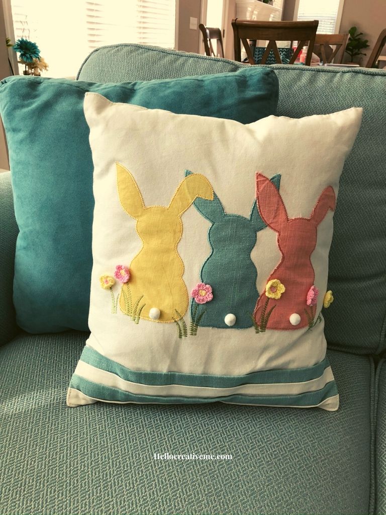 three colored bunnies on a pillow