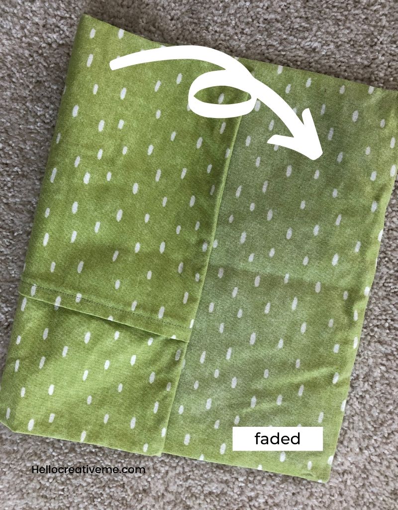 Green pillow cover showing faded and unfaded sides.