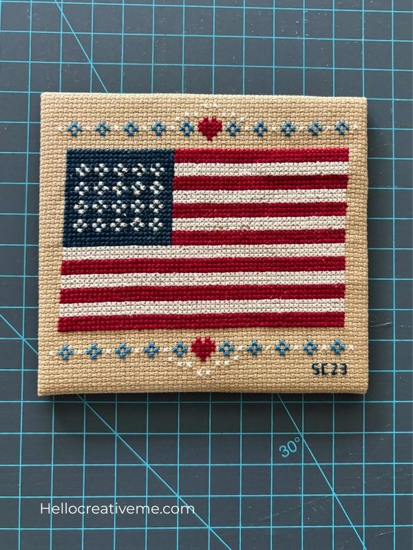 DIY cross stitch of American flag project mounted on sticky back board.